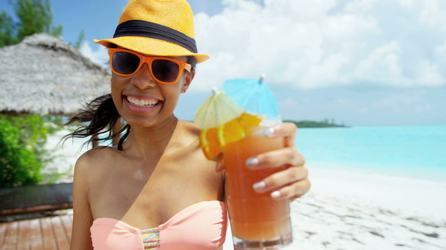 Happy young African American girl enjoying party cocktail on beach