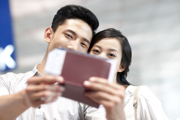 Young couple at the airport with flight tickets and passports