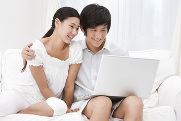 Young Couple Using Laptop at Home