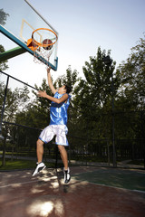 Young Man Playing Basketball © Blue Jean Images