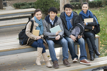 Fototapeta premium A group of college students sitting on a bench 
