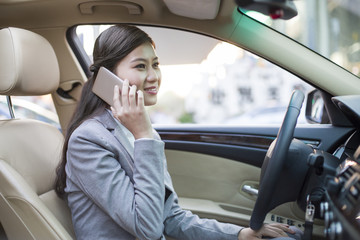Businesswoman talking on the phone in a car