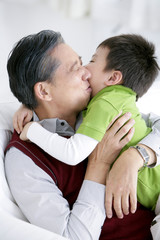 Chinese grandfather kissing grandson