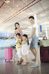 Cheerful family with luggage at the airport