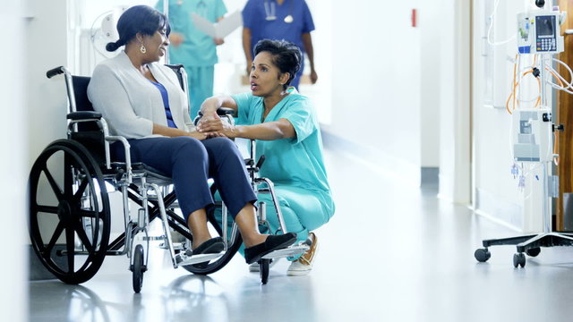 African American female staff and disabled patient consult in medical center 