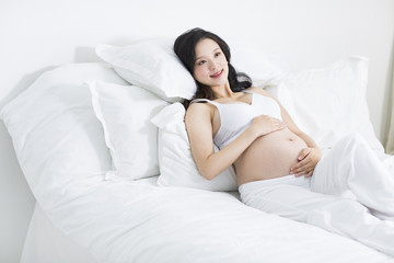 Obraz na płótnie Canvas Pregnant woman resting in bed