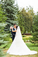 bride and groom kissing in park