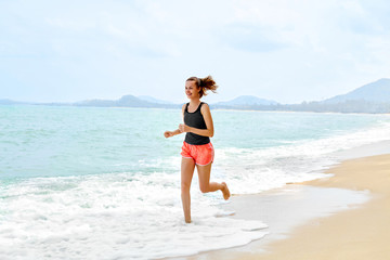 Fototapeta na wymiar Fitness. Sporty Young Female Runner Running On Beach. Athletic Fit Woman Jogging During Workout Outside. Sports, Exercising, Healthy Lifestyle. Health Concept