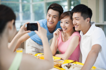 Young adults taking pictures in restaurant