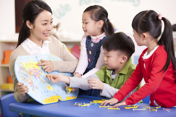 Female teacher teaching kindergarten children geography