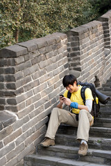 Fototapeta na wymiar Young people using cellphone on the Great Wall