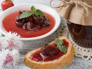 Canned strawberry confiture and jam sandwich on the wooden board