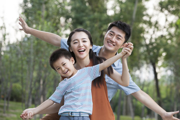 Portrait of happy young family with arms outstretched