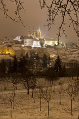 Fototapeta na wymiar Night foggy snowy Prague City with gothic Castle, Czech republic