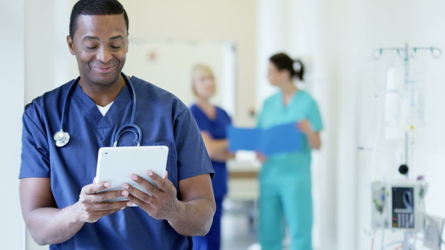 African American male staff working on tablet technology in hospital