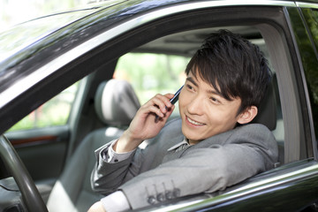Businessman on the phone inside car