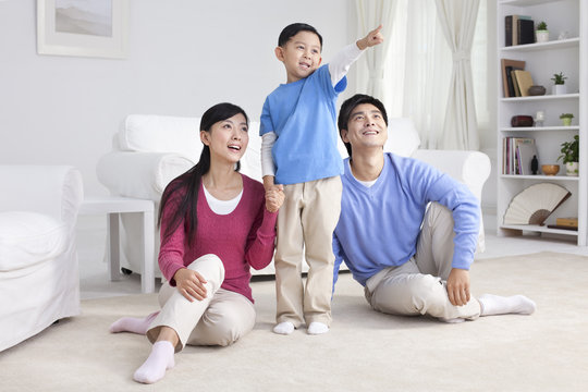 Young Chinese family with son pointing