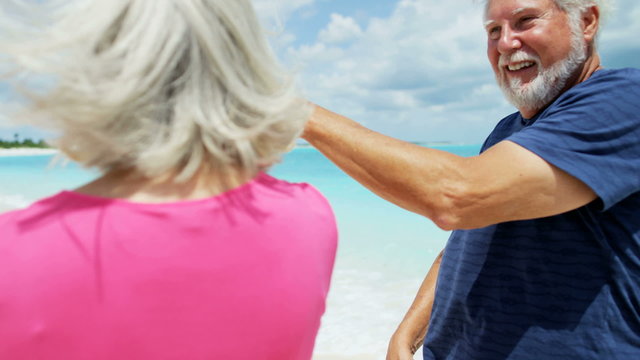 Loving retired Caucasian couple dancing outdoor on the beach 