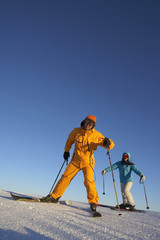 Young man and young woman skiing