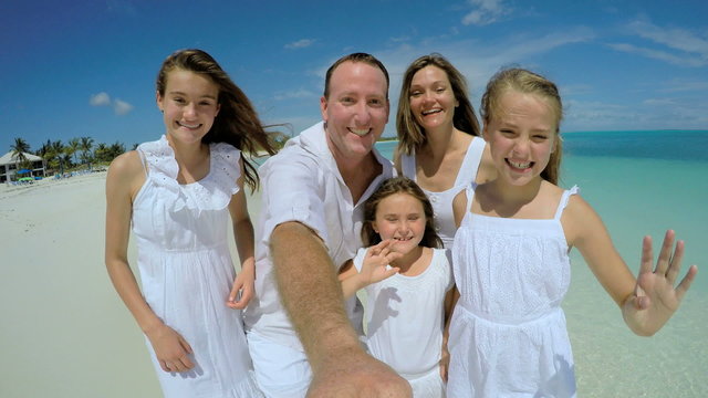 Caucasian family in white clothes filming video selfie on the beach 