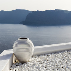 White vase with pebbles on rooftop in Santorini