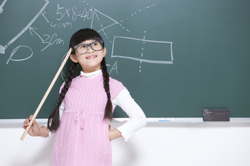 Humorous little girl playing teacher in classroom