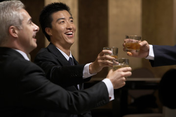 Three business leaders share a toast at an exclusive business club