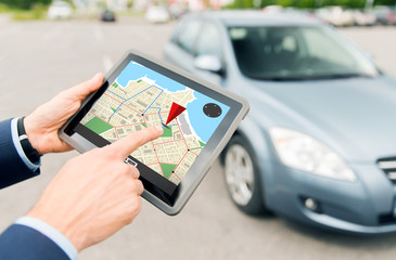 close up of hands with gps on tablet pc and car