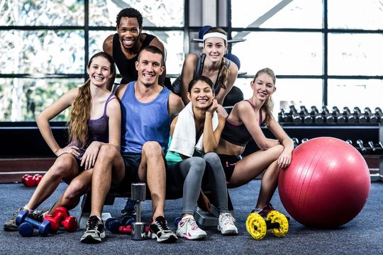 Smiling fitness class posing together