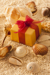 Shell and gift box in sand