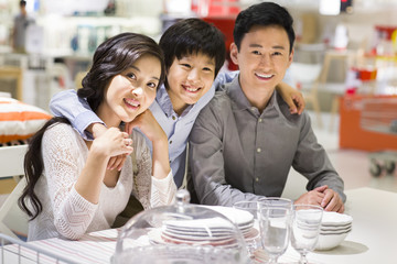 Cheerful family sitting side by side and smiling