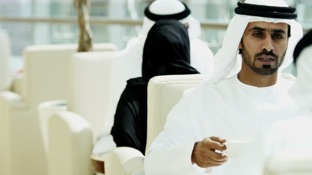 Emirati male business colleagues meeting oil commodity tablet technology