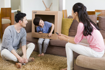 Happy family playing cardboard television