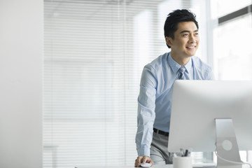 Young businessman using computer in office