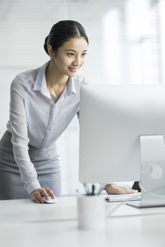 Young businesswoman using computer in office
