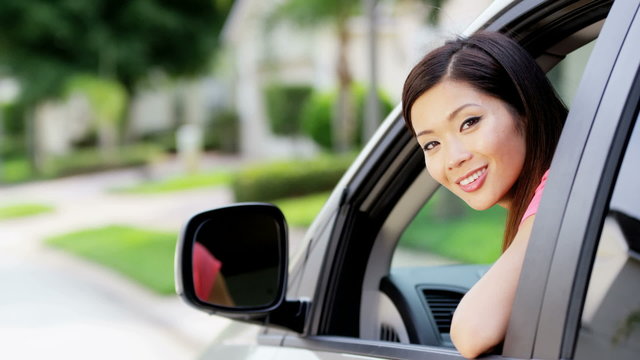 Portrait of young pretty Asian American woman buying new vehicle
