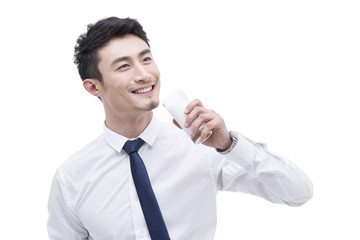 Happy young businessman with milk
