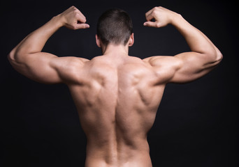 handsome young bodybuilder with toned body posing shirtless