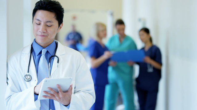 Asian American male young doctor working on tablet technology in hospital