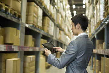 Businessman using digital tablet in warehouse