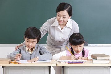 Happy schoolchildren and teacher talking