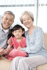 Elderly couple with granddaughter on couch