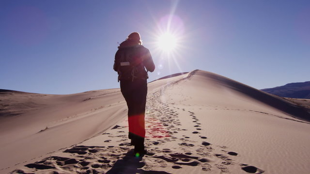 Female climber desert sun flare sky heat sand hiker