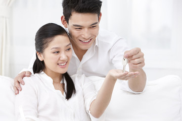 Happy couple holding up keys