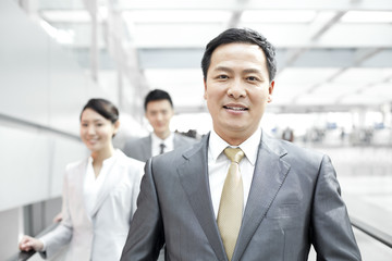Confident business people in airport lobby