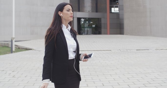 Young woman taking a call using earplugs