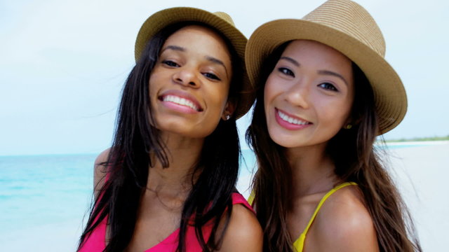 Portrait of African American Asian Chinese girls with hat on beach 