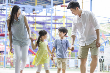 Fototapeta premium Happy young family playing in amusement park