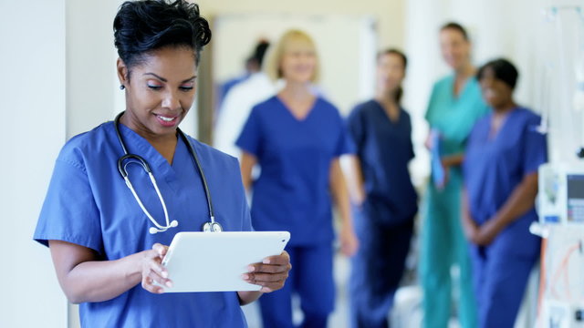 Professional African American female nurse working on technology in hospital