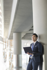 Young businessman using laptop in airport